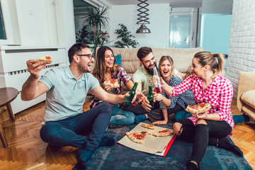 Group of young friends eating pizza.Home party.Fast food concept.