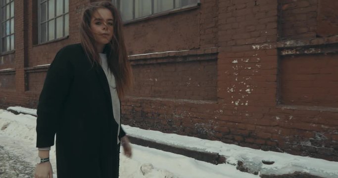 a beautiful girl walks through the grey streets