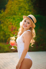 Slim fashion model in a swimsuit posing near the pool