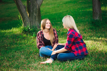 lifestyle and people concept: Two young girl friends sitting together and having fun.