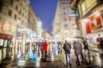 people walking on rainy night streets in vienna