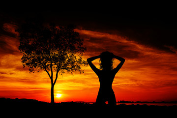 Silhouette of a young and fit woman on the beach at sunset