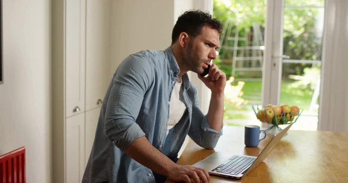 4K Professional man with laptop dealing with business problems over the phone