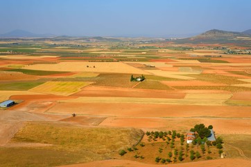 Fototapeta na wymiar ラ・マンチャ地方のパッチワークのような田園風景 赤茶色の大地と田園風景に圧倒された。