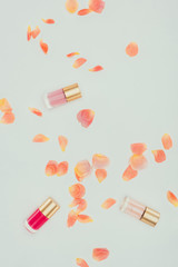 beautiful tender rose petals and nail polishes on grey