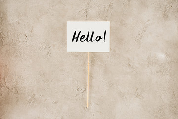 top view of hello lettering on placard on concrete surface