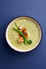 Vegaterian winter split pea turmeric soup on dark blue background, close-up, top view, vertical