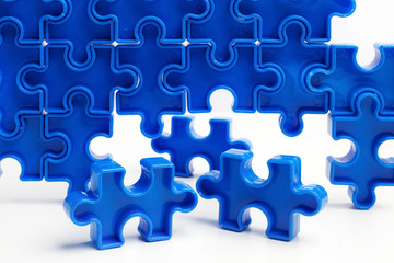 Pieces from a blue jigsaw puzzle arranged to form a page on white background. Break barriers together for autism concept