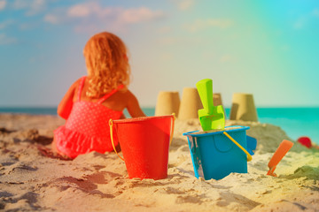 little girl play with sand on beach