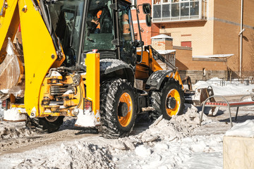tractor removes snow in the yard