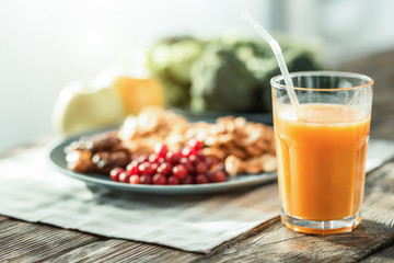 GMO free. Fresh peach juice being on the table near the plate of products.