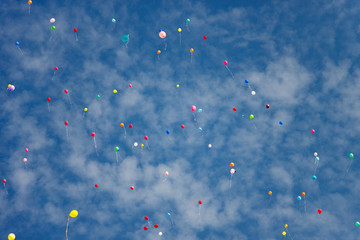 Multicolored balloons flying against the blue sky