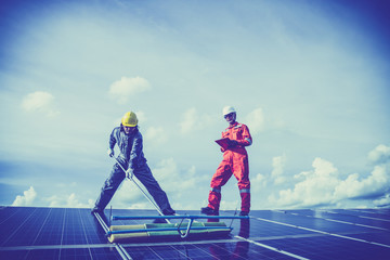 Fototapeta premium operation and maintenance in solar power plant ; engineering team working on checking and maintenance in solar power plant ,solar power plant to innovation of green energy for life.
