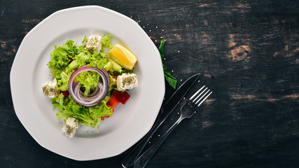 Greek Salad from Fresh Vegetables. On a wooden background. Top view. Copy space.