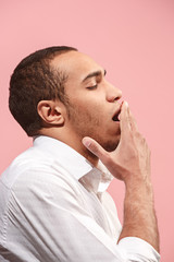 Beautiful bored man bored isolated on pink background