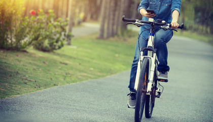 Fototapeta na wymiar cyclist use cellphone while riding bike in tropical park
