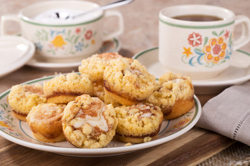 Plate of cinnamon cream cheese coffee cake and cup of coffee and sugar bowl in background