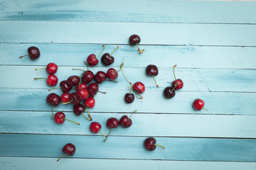 Fototapeta na wymiar cherries on turquoise wooden background