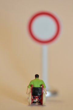miniatura di disabile in sedia a rotelle davanti ad un divieto di accesso