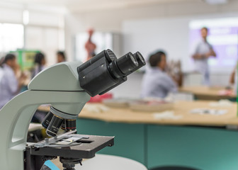 Biology or chemistry science class study with microscope and blur background of school student...