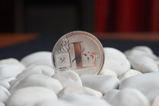 Litecoin coin stuck between white stones