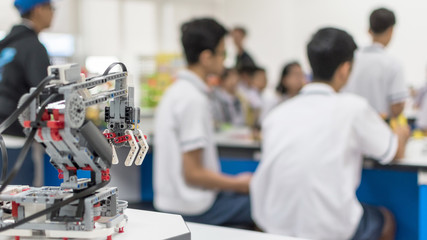 Robotic lab class with school students blur background learning in group having study workshop in science technology engineering classroom for education concept