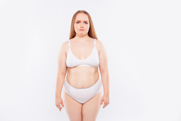 Young woman stands in underwear and frowns