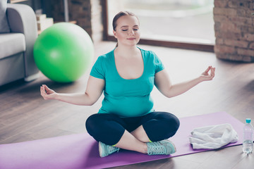 Naklejka premium Young woman doing yoga pose on mat at home
