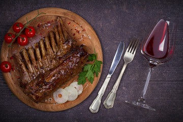 Grilled rack of lamb in balsamic vinegar and brown sugar sauce, glass and bottle of wine. Lamb chops with vegetables. Red wine and meat