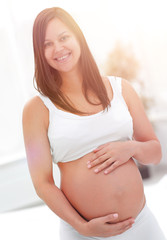 portrait of young pregnant woman on a light background.