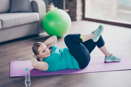 Young woman exercising on mat at home