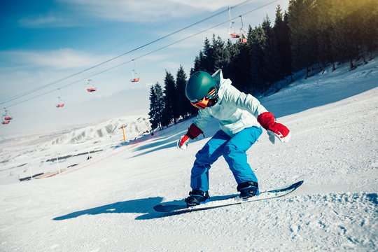 one young woman snowboarding in winter mountains