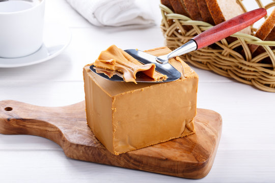 Norwegian brunost traditional brown cheese block and slicer Stock Photo by  duskbabe