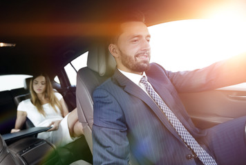 businessmen with a computer in the car go on a business trip