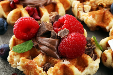 Belgian waffles with pomegranate and raspberries, homemade healthy breakfast with mint