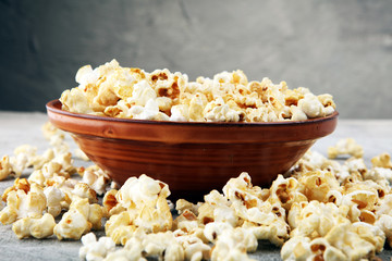 Salt popcorn or sweet popcorn on old grey background.