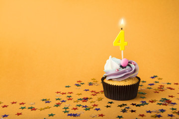 Fourth birthday cupcake with candle and sprinkles