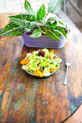Smoke salmon dumpling salad on a white plate and on a light wooden table. Chinese food. Food chopsticks. Top view with copy space. 