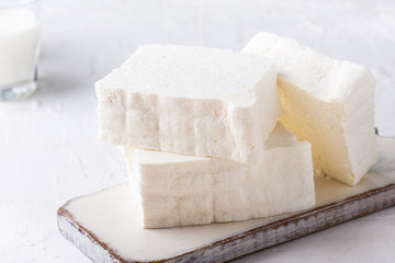 Fresh cottage cheese on rustic white wooden board
