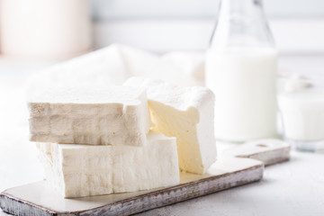 Fresh cottage cheese on rustic white wooden board