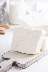 Fresh cottage cheese on rustic white wooden board