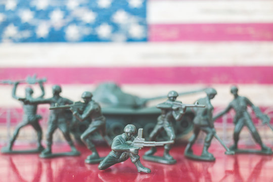 Miniature toy soldiers in battle scene with american flag background , Memorial Day concept
