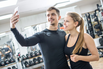Fototapeta na wymiar Young couple taking a sefie in a gym