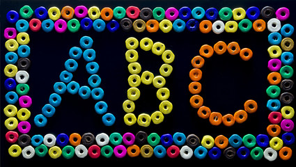 abc print created with beads on black background