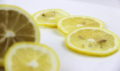 bright, yellow lemons. whole and sliced on a plate.