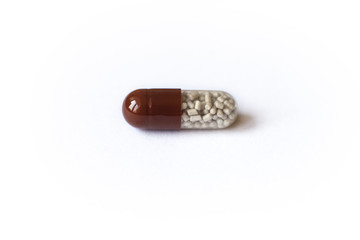 brown medical capsule on white background