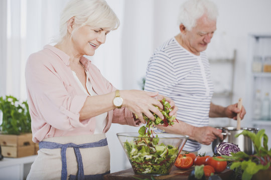Older woman tossing a salad
