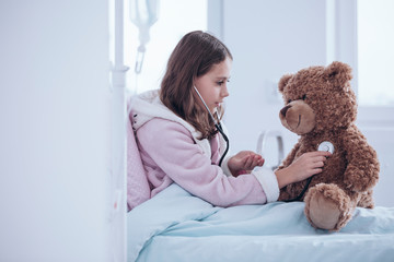 Girl examining teddy bear