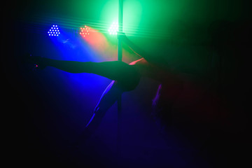 Young slim pole dance woman in bright interior