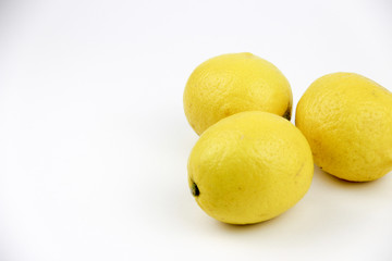 bright, yellow lemons. whole and sliced on a plate.